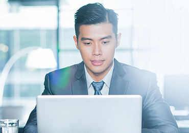 Advisor in suit working on laptop
